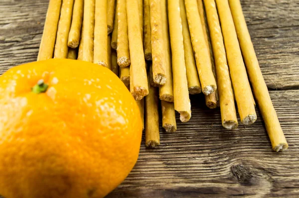 Bâtonnets et mandarines sur fond bois — Photo