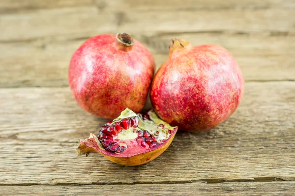 Granátové jablko izolovaných na dřevěné pozadí — Stock fotografie