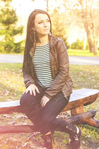 Girl sitting on bench outdoors — Stock Photo, Image