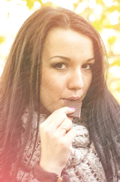 Retrato de uma fêmea comendo chocolate ao ar livre — Fotografia de Stock