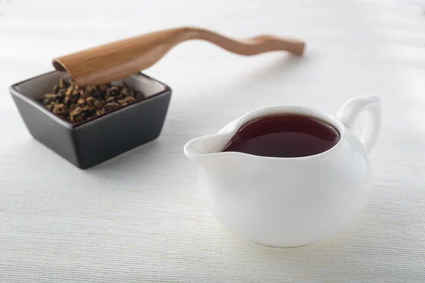 Black tea and tea leaves with wooden spoon