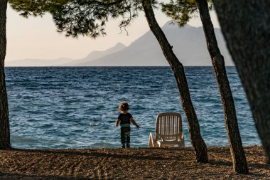 Makarska, Hırvatistan, Sahilde yalnız yürüyen bir çocuk.