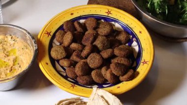 Bir kase falafel, humus, salata ve pide ekmeği..