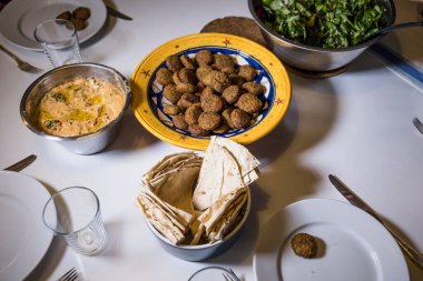 Bir kase falafel, humus, salata ve pide ekmeği..