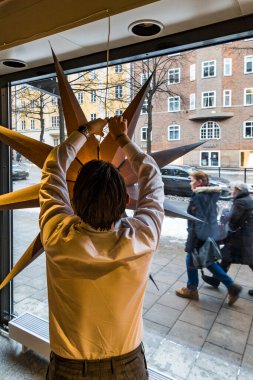 Stockholm, İsveç Noel 'de bir adam bir yıldızı asıyor..