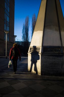 Stockholm, İsveç Bir kişi ve gölgeleri Sodermalm 'da Medborgaplatsen' de kış güneşinde.
