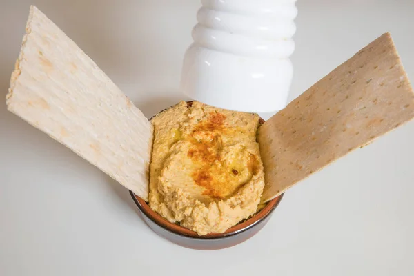 Hummus Einer Schüssel Mit Crackern Und Pfeffer — Stockfoto