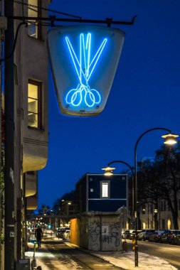 Stockholm, İsveç Hagerstensvagen 'deki bir kuaför / berber dükkanının üzerinde bir makas işareti var..