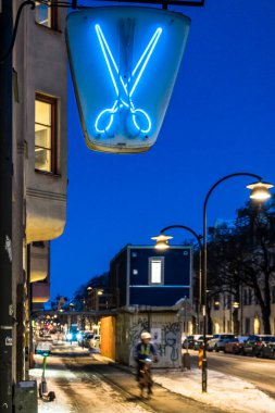 Stockholm, İsveç Hagerstensvagen 'deki bir kuaför / berber dükkanının üzerinde bir makas işareti var..