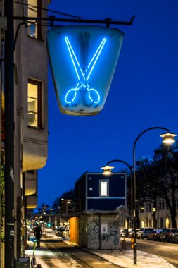 Stockholm, İsveç Hagerstensvagen 'deki bir kuaför / berber dükkanının üzerinde bir makas işareti var..