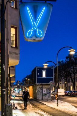 Stockholm, İsveç Hagerstensvagen 'deki bir kuaför / berber dükkanının üzerinde bir makas işareti var..