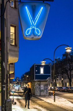 Stockholm, İsveç Hagerstensvagen 'deki bir kuaför / berber dükkanının üzerinde bir makas işareti var..