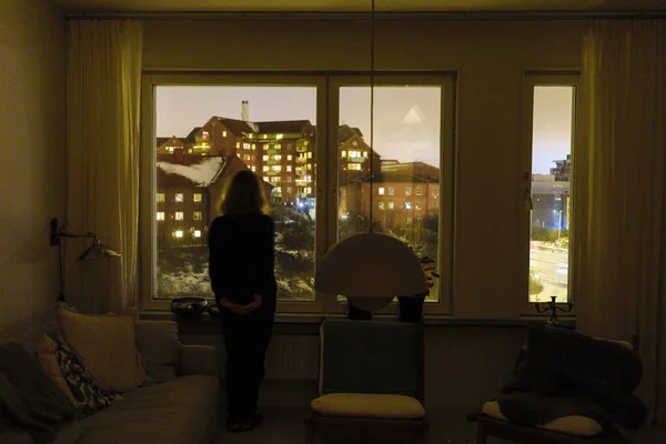 ストックホルム スウェーデン眠れない女性は夜にアパートの窓に立っています — ストック写真