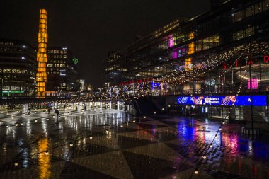 Stockholm, İsveçli yayalar Sergels Torg 'da gece yağmurda.