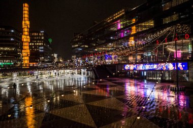 Stockholm, İsveçli yayalar Sergels Torg 'da gece yağmurda.