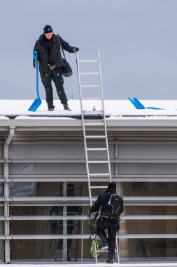 Sundsvall, İsveç. İki adam bir binanın çatısından buz ve kar kaldırıyor..