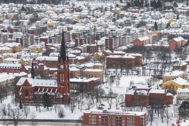 Sundsvall, İsveç Kış boyunca bir yamaçtan karla kaplı şehir manzarası ve Gustav Adolf Kilisesi.