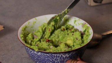 Bir insan kasede guacamole karıştırır.. 