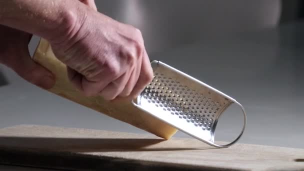 Person Grates Parmesan Cheese Wooden Cutting Board — Stock Video
