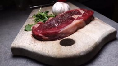 Mutfaktaki kesme tahtasının üzerinde 200 gramlık bir et parçası.. 
