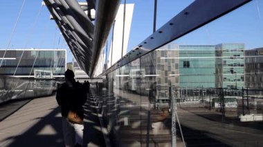 Oslo, Norveç Barkod bölgesindeki merkez tren istasyonunda yaya köprüsünden geçen insanlar.