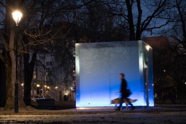 Oslo, Norveç yayaları Grunerlokka bölgesindeki Sofienberg Parkı 'nda mavi ışık kübünün önünde yürürler..