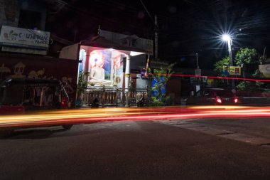 Galle, Sri Lanka Trafik Wizzaları Buddah heykelinin yanında gece bir sokak köşesinde.