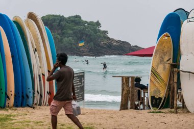 Hiriketiya Plajı, Sri Lanka Turistleri Ukrayna bayrağı altında sörf yapıyor.