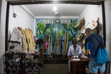 Mirissa, Sri Lanka Bir adam yol kenarındaki sörf dükkanından sörf tahtası kiraladı.