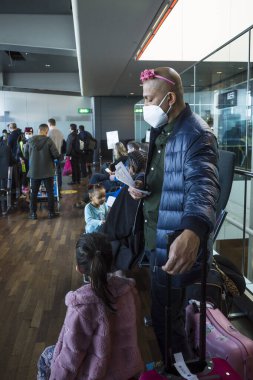 Stockholm, İsveç Havaalanı 'nda maskeli ve kızının tacını takmış bir adam bekliyor..
