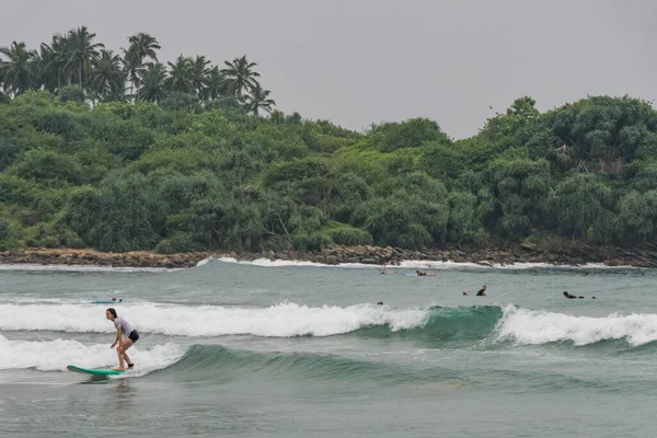 スリランカのヒリケティヤビーチ波に乗ってサーフィンするサーファーの観光客 — ストック写真