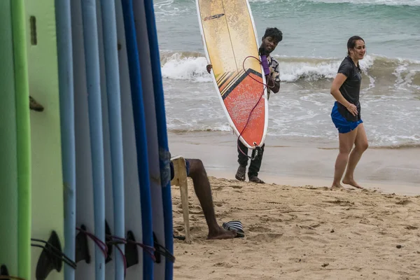 スリランカのHiriketiya Beach地元の人は彼女のボードでサーファーを助けます — ストック写真
