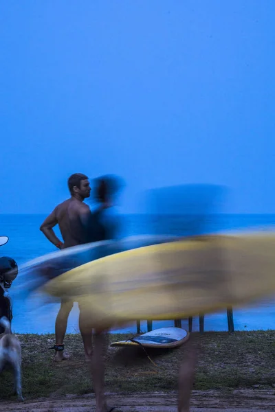 スリランカのミリッサ早朝サーフボードを持った男が海岸沿いに立っている — ストック写真