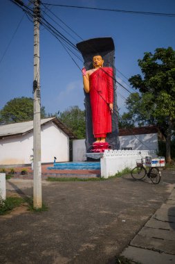 Ella, Sri Lanka. Yolun kenarında kırmızı bir Buda heykeli duruyor..
