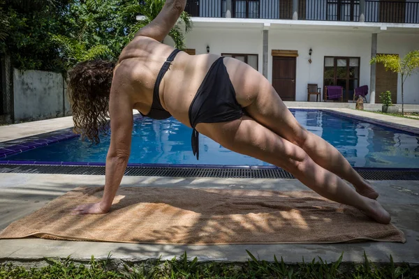 斯里兰卡 一个女人在游泳池边做瑜伽 — 图库照片