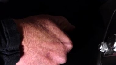 Bir adam otomobilde kontağı çevirir.. 