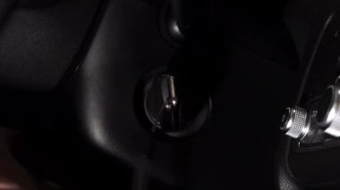 Bir adam otomobilde kontağı çevirir.. 