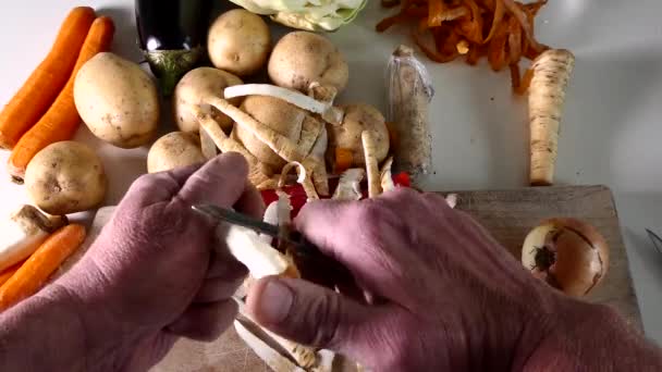 Man Peels Vegetables Potatoes Carrots Peppers Cabbage Kitchen Table — Stock Video