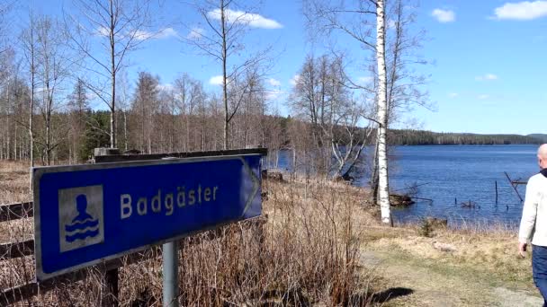 Saffle Швеция Мужчина Ходит Нетронутому Голубому Озеру Знак Шведском Говорит — стоковое видео