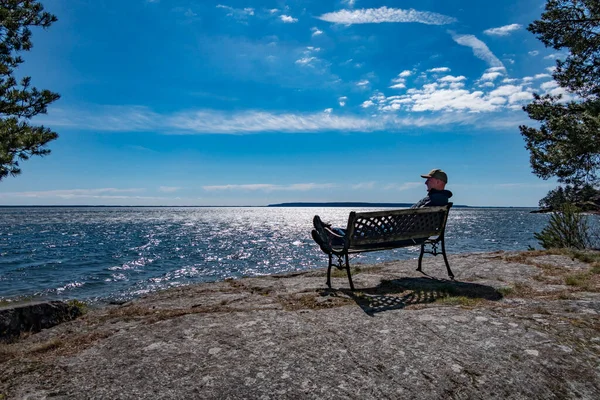 ヴァナースボースウェーデンヴァナーン湖を見下ろすベンチでリラックスした男 — ストック写真