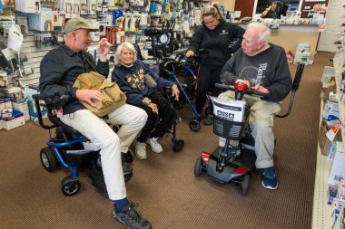 Solomons, Maryland USA. Son sınıf çift elektrikli sandalye ya da scooter için alışveriş yapıyor..