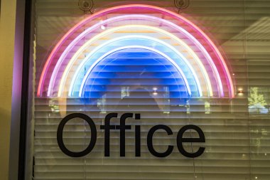 Ofisteki bir tabelada gökkuşağı sembolünün altında yazıyor..