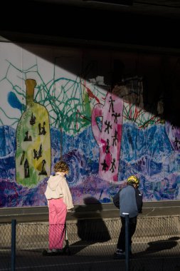 Stockholm, İsveç Liljeholmen 'de güneş ışığında yürüyen insanlar.