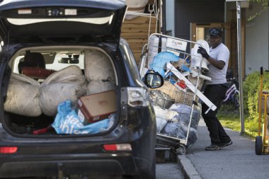 Stockholm, İsveç. Bir adam kaldırımda kişisel eşyalarıyla dolu bir tramvayla boğuşuyor..