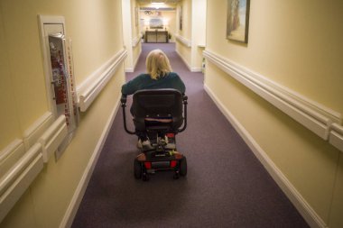 Solomons, Maryland USA. Son sınıf öğrencisi bir kadın koridorda elektrikli sandalyeyle manevra yapıyor..