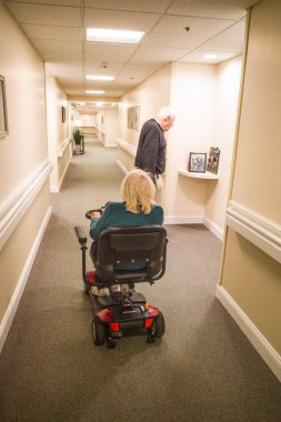 Solomons, Maryland USA. Son sınıf öğrencisi bir kadın koridorda elektrikli sandalyeyle manevra yapıyor..