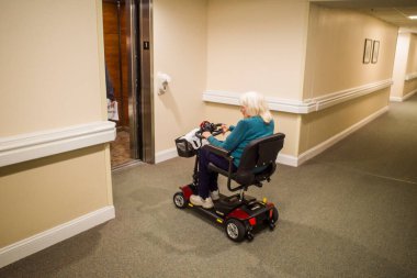 Solomons, Maryland USA. Son sınıf öğrencisi bir kadın koridorda elektrikli sandalyeyle manevra yapıyor..