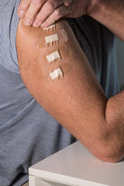 Man Arm Four Bandaids Representing Four Innoculations Including Booster Shot — Foto de Stock