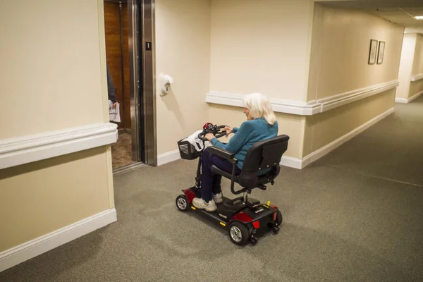 Solomons, Maryland USA. Son sınıf öğrencisi bir kadın koridorda elektrikli sandalyeyle manevra yapıyor..