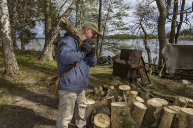 Stockholm, Sweden A man carries wood to a woodpile for later splitting as part of a community project.